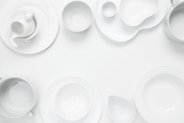 Photo set of different pure white dishes for home or restaurant on white background top view flat lay