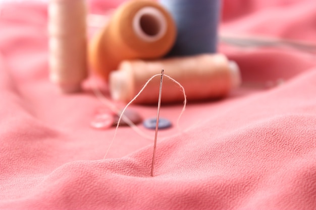 set of different sewing accessories on a colored background closeup