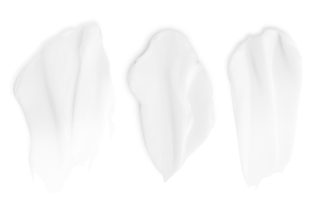 A set of different strokes of white cream on a white background