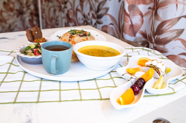 set of dishes for lunch chicken soup pilaf with salvt hot tea and bun