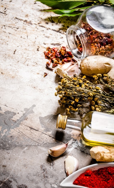 A set of dried spices and herbs with olive oil. On rustic background.