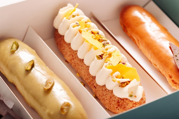 Set of eclair cakes with different fillings in a box closeup Traditional french dessert