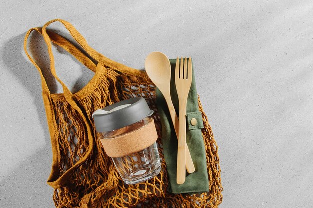 Set of Eco friendly bamboo cutlery, eco bag and reusable coffee mug. Sustainable lifestyle. Plastic free concept.