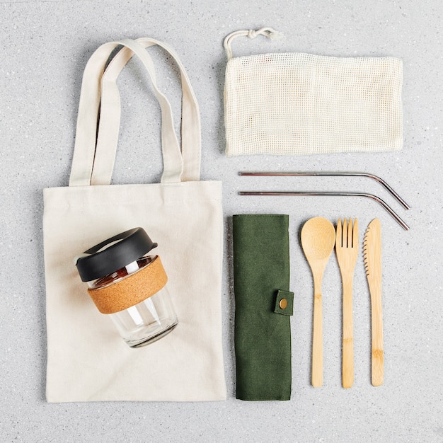 Set of Eco friendly bamboo cutlery, eco bag and reusable coffee mug. Sustainable lifestyle. Plastic free concept.