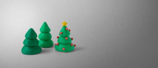 Set of elegant shapes of christmas pine trees made of green plasticine with copy space