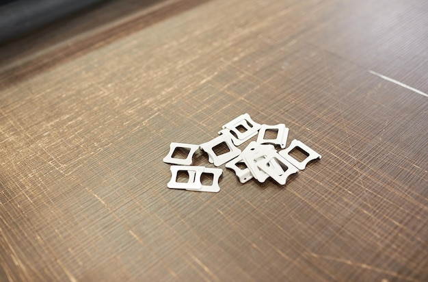 A set of fasteners and handles for a mosquito net is laid out on a wooden table