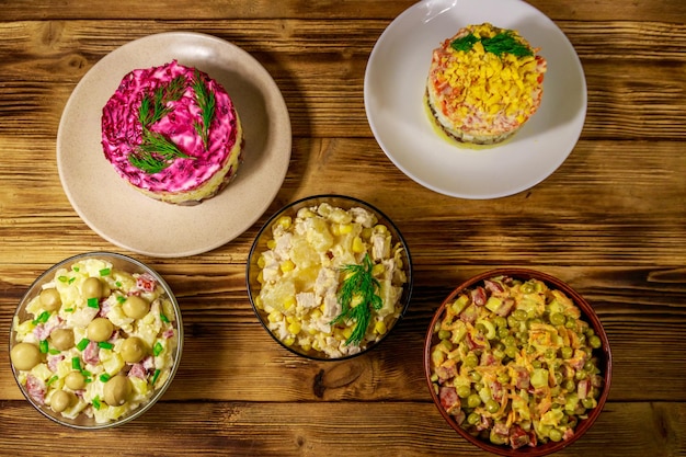 Set of festive mayonnaise salads on wooden table. Top view