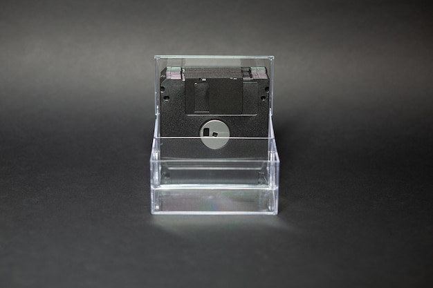 Set of floppy disks in a transparent box on a black background on the table