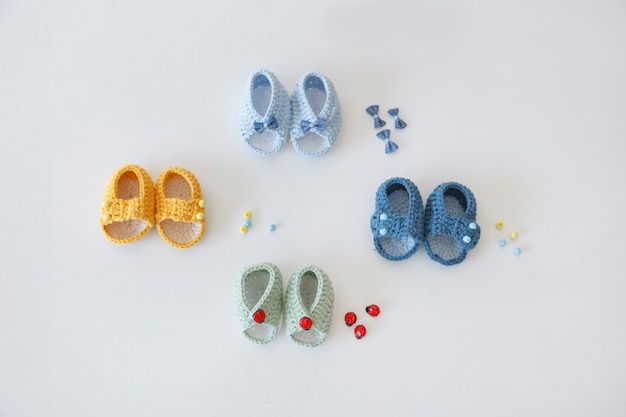 Photo set of four pairs of hand made baby bootees with buttons