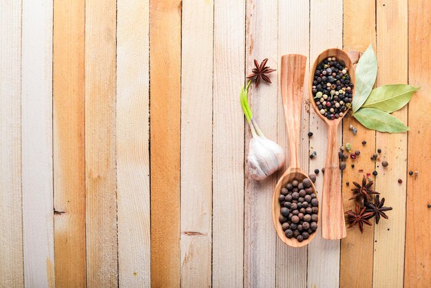 A set of fragrant spices. A mixture of black and red pepper, coriander, paprika. On Wooden background. Top view. Free space.