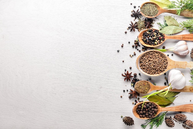 A set of fragrant spices A mixture of black and red pepper coriander paprika On Wooden background Top view Free space