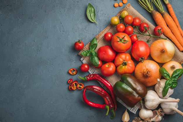 A set of fresh vegetables for cooking a vegetable dish sauce on a dark background