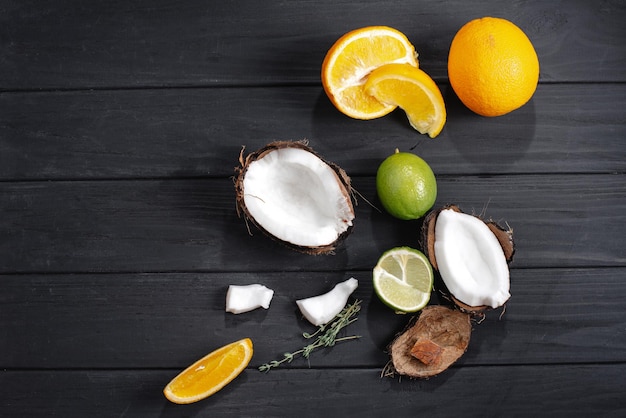 Set of fruits tropical lime coconut on orange the background of an old dark wooden table top view fl