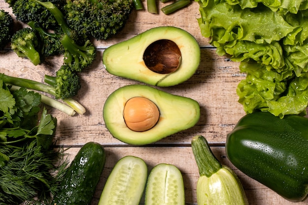 A set of green vegetables on a wooden background.