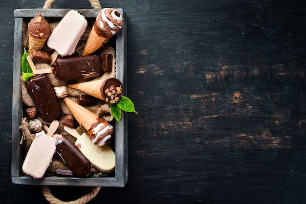 A set of ice cream with chocolate nuts and jam On a black background Top view Free copy space