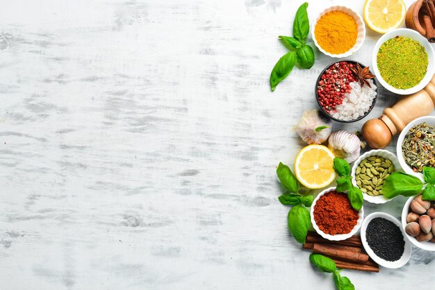 Set of Indian spices basil and herbs on a white wooden background Top view Free space for text