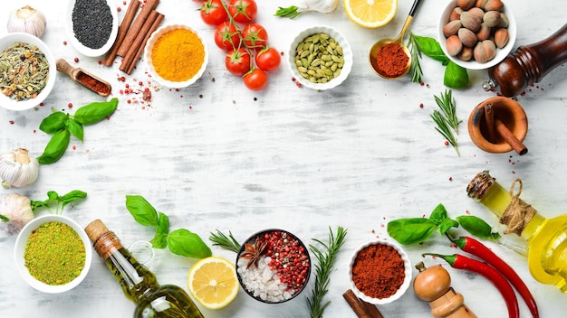 Set of Indian spices basil and herbs on a white wooden background Top view Free space for text