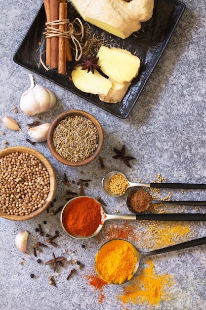 Set of Indian spices and herbs selection on a stone table Top view flat lay background