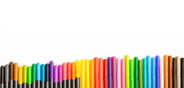 Set of markers of different colors arranged side by side on white background