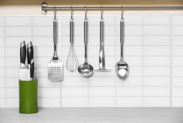 Set of metal kitchen utensils hanging on wall