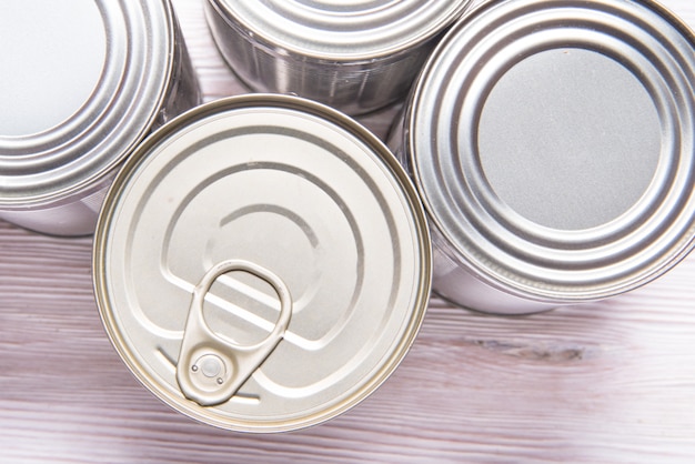 Set of metal tin cans on wooden table