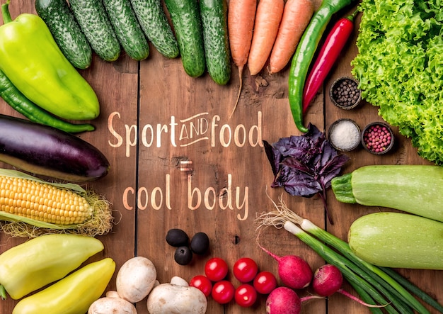 The set of multicolored vegetables, herbs and spices on wooden table.