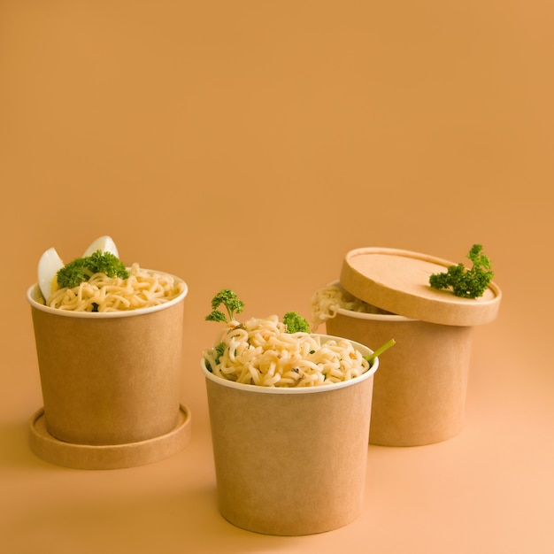 A set of noodles in a glass with herbs and vegetables. Copy space