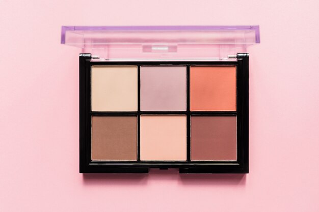 Set of nude eyeshadows in black case on pink background. Top view , copy space