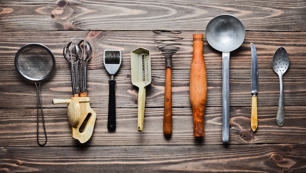 A set of old kitchen tools and cutlery on a wooden table. Vintage cooking in the kitchen. Top view.