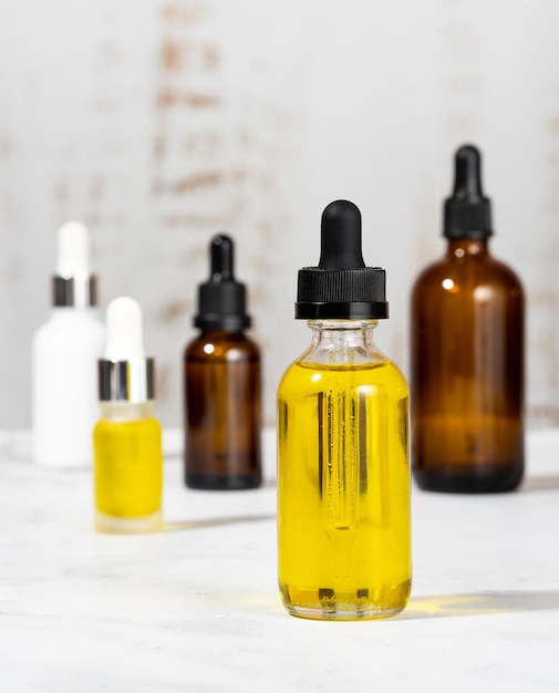 A set of organic cosmetics in glass vials with dropper for skin and hair care Bottles with essential oils on the cosmetic table in the bathroom The concept of self care and spa Foreground focus