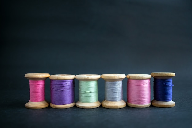 Set of pastel colors thread for sewing on a black background