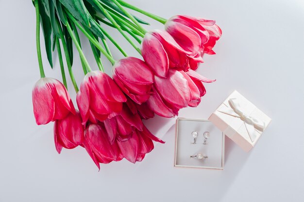 Set of pearl jewellery in gift box with flowers.