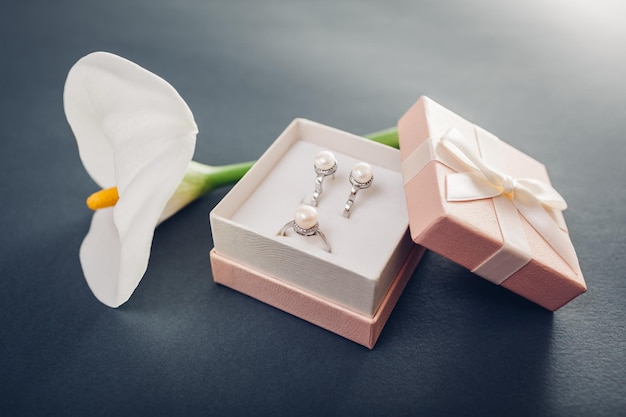 Set of pearl jewellery in the gift box with lily flowers