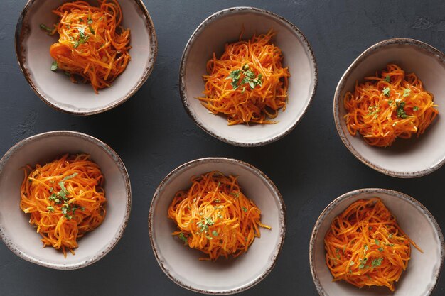 Set on plates with russian korean salad in restaurant on black background, top view