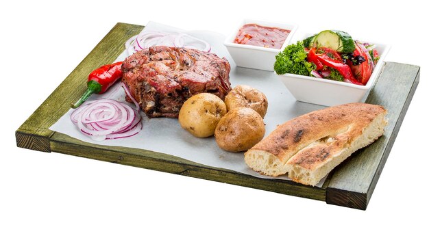 Set of pork steak vegetable salad potatoes and sauce On a wooden board Chalagach