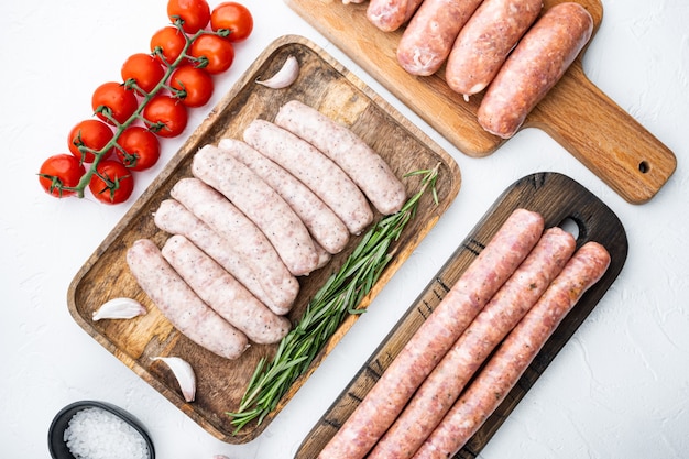 Set of raw pork, beef and chicken sausages, flat lay, on white background