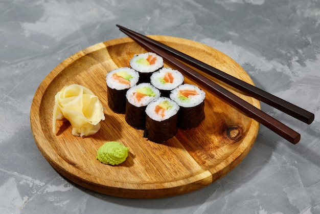 Set of rolls on a round wooden board on a gray background