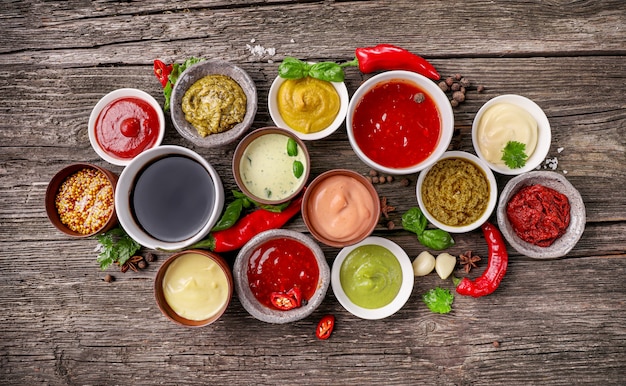 Set of sauces in small bowls on wooden