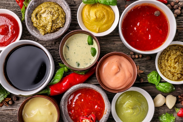 Set of sauces in small bowls on wooden