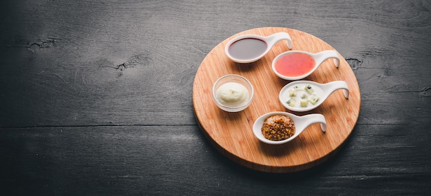 A set of sauces and spices. On a wooden background. Top view. Free space for text.