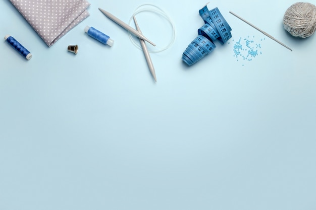 Set of sewing accessories on a blue background, top view