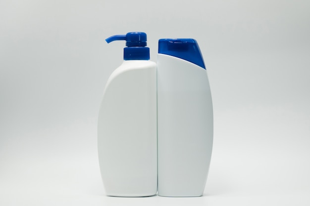 Set of shampoo and conditioner bottle with blue cap and dispenser pump on white background with blank label and  copy space. Use for advertise shampoo and conditioner. Cosmetic product package. Beauty