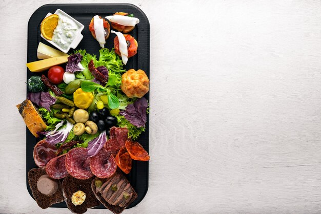 Set snacks with meat and pickled vegetables Italian cuisine Top view On Wooden background