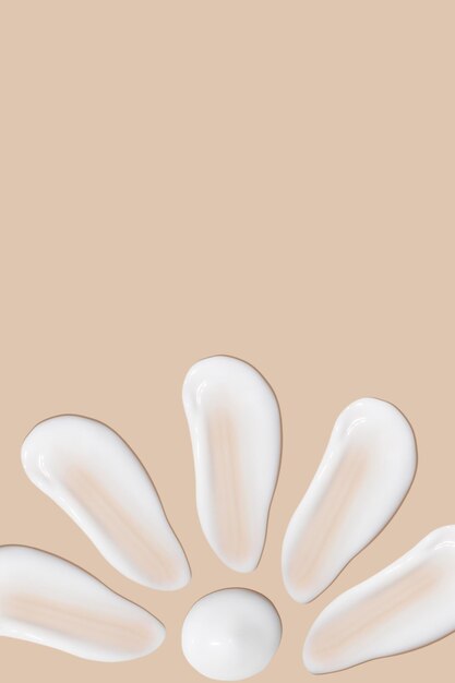 A set of strokes of white cream on a beige background