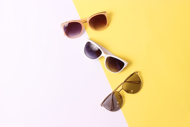 Set of sunglasses on a colored background top view