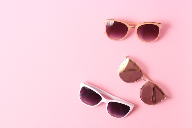 Set of sunglasses on a colored background top view