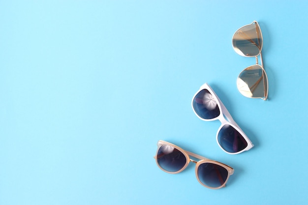 Set of sunglasses on a colored background top view