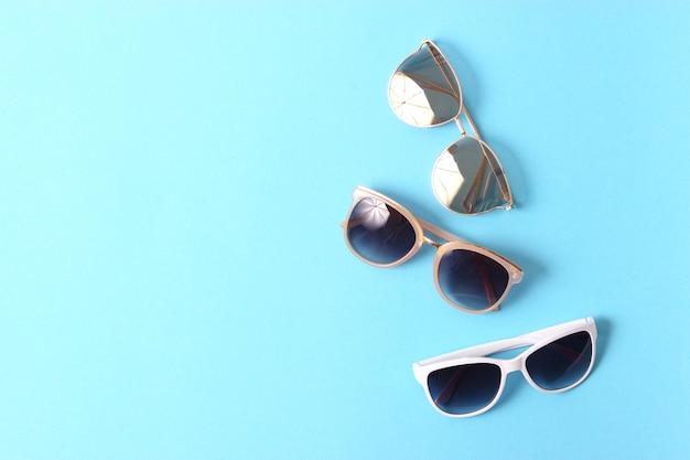 Set of sunglasses on a colored background top view