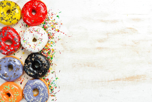 Set of sweet colored donuts on a white wooden background Top view Flat Lay