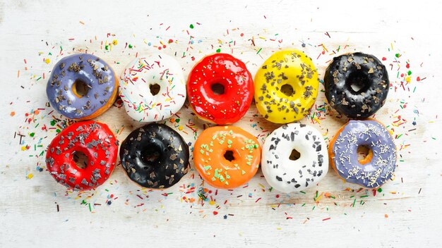 Set of sweet colored donuts on a white wooden background Top view Flat Lay